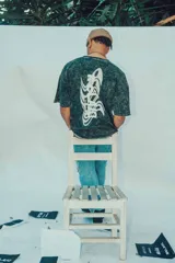 Remerón negro de corte amplio con estampa en la espalda con la palabra "RELAX" en letras blancas con efecto ondulado.
