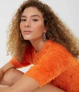 Blusa color naranja con textura de peluche, manga corta y cuello redondo.