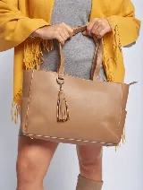 Cartera tote color marrón topo, de cuero sintético, con doble asa corta y cierre superior. Incluye un dije colgante con borla.