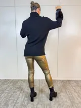 Polerón negro de viscosa y nylon, con cuello alto, mangas largas con puños de piel sintética y corte asimétrico.