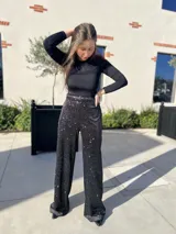 Pantalón negro con lentejuelas plateadas, de corte palazzo y cintura alta.