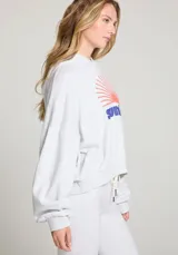 Hoodie gris jaspeado con capucha y mangas amplias. Estampado frontal con la palabra "Sunday" en azul y un sol naciente en naranja.