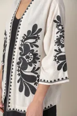 Saco color crudo de lino y viscosa con bordado de hilo de seda negro, de corte suelto y mangas tres cuartos.
