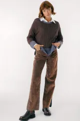 Sweater color camel con tejido de trenzas y terminaciones en color beige.