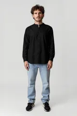 Camisa blanca de cuello mao y mangas 3/4 con botón para sujetar.