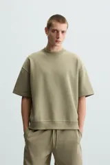 Sudadera relaxed fit color crudo confeccionada en tejido interlock de algodón con elasticidad, cuello redondo, manga corta y bajo acabado en rib.