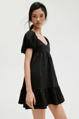 Vestido corto negro con escote corazón, mangas cortas abullonadas con elástico en hombros y puños, espalda fruncida y falda con vuelo.