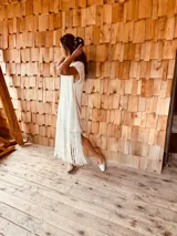 Vestido tejido color blanco con hilo metalizado, corte oversized, mangas cortas y flecos en el ruedo.