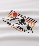 Remera de algodón color blanco crudo, corte comfort, cuello redondo y manga corta. Presenta un estampado localizado en el pecho con montañas, un sol y las palabras "WILD - FREE -".