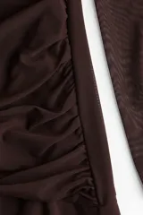 Vestido largo marrón de malla con delantero drapeado, cuello redondo, mangas largas y falda con leve vuelo.
