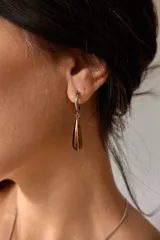 Aros colgantes de acero quirúrgico hipoalergénico con dije de piedra natural en forma de gota color azul oscuro.