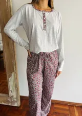 Conjunto de pijama gris melange con estampado floral, compuesto por una remera de manga larga con cuello redondo y botones, y un pantalón largo con cintura elástica y lazo ajustable.