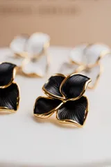 Aros colgantes con forma de flor, con pétalos negros y borde dorado.