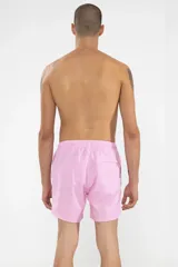 Short de baño rosa con estampado de lunares blancos, cintura elástica con cordón ajustable, bolsillos laterales y trasero con cierre, logo de la marca bordado en la pierna y suspensor de malla fina.