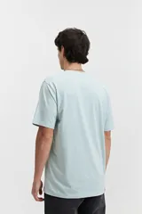 Remera celeste de manga corta con cuello redondo y estampado con letras en el frente.
