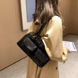 Cartera en color tostado, con dos bolsillos frontales y diseño elegante.