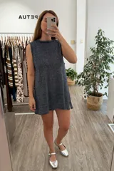 Vestido tejido de manga corta y cuello redondo, color azul oscuro con brillo metálico (lurex). Presenta un corte recto y holgado.