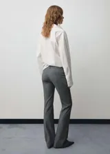 Pantalón gris acampanado de tiro medio con trabillas, bolsillos traseros de ribete y cierre oculto de botón, gancho y cremallera.