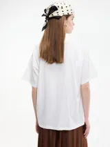 Camiseta blanca de algodón con cuello redondo y mangas cortas. Estampa frontal con la frase "Ride the Wave" y una imagen de una persona surfeando.