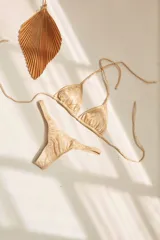 Conjunto de bikini verde esmeralda, con corpiño triangular de atar al cuello y espalda, con almohadillas desmontables, y bombacha colaless con laterales fijos.