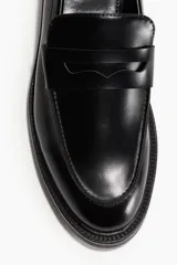 Mocasines negros de cuero sintético con suela track y detalle de antifaz liso.