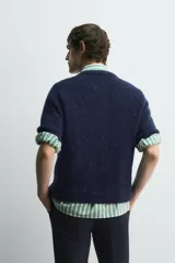 Cárdigan azul marino de manga corta tejido en hilatura con lana y alpaca, de textura suave. Tiene cuello redondo, rib en los bordes y cierre frontal con botones. Edición especial Harry Lambert for Zara x Disney.