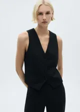 Chaleco negro con cuello en pico, diseño crop y cierre frontal con botones.