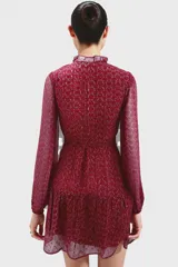 Vestido corto color borgoña con estampado de círculos y mangas largas abullonadas.