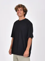 Remera negra de manga corta, con cuello redondo y calce amplio u oversize.