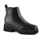 Bota corta color marrón con plataforma y taco bajo. Presenta detalle de costuras en la parte delantera y cierre lateral.