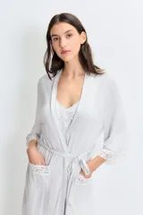 Bata gris claro melange de modal jersey con detalle de puntilla en mangas y ruedo. Tiene lazo para ajustar en la cintura y detalle bordado en el pecho.