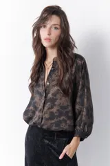 Camisa marrón con estampado abstracto en tonos cobre y negro, cuello mao y mangas largas abullonadas con puños elásticos.