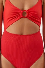 Traje de baño entero rojo con textura acanalada, breteles anchos regulables, abertura en el abdomen y aro metálico en el centro del busto.