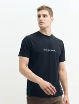 Remera negra de algodón con cuello redondo y estampado frontal con la frase 'All you need' en color blanco.
