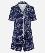 Pijama de dos piezas compuesto por una blusa de manga corta con cuello y cierre de botones, y un short con cintura elástica. El conjunto es de color azul marino con un estampado integral de flores y frutas en blanco, con ribetes blancos en los bordes.