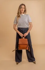 Mochila color verde oliva, tipo cartera, con tapa y doble cierre. Tiene dos compartimentos y división interna, además de un bolsillo trasero con cierre.