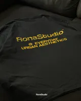 Remera negra oversize de algodón pesado premium, con estampa amarilla en la espalda con el logo de la marca y la frase "Everyday Urban Aesthetics".