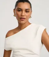 Blusa de crepé color blanco, con escote asimétrico, manga corta y drapeado lateral.