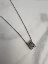 Collar de cadena fina plateada con dije de la letra "F" incrustada con strass.