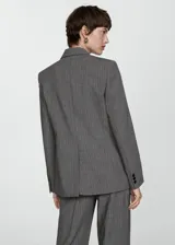 Blazer gris con raya diplomática, cuello con solapa, cierre frontal con botón y mangas largas abotonadas.