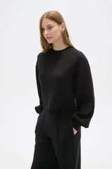 Buzo color marrón con cuello redondo y mangas largas abullonadas.