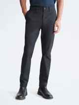 Pantalón chino de corte slim color negro, con bolsillos laterales y traseros, cierre con cremallera y botón, y trabillas para cinturón.