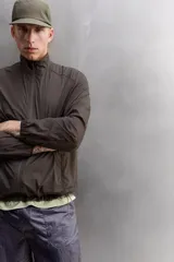Cazadora relaxed fit confeccionada en tejido técnico ligero color marrón. Cuello subido, manga larga acabada en puño con elástico, bolsillos frontales en cadera con cierre de cremallera oculta en costura y cierre frontal con cremallera.
