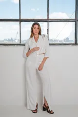 Conjunto de dos piezas color blanco, compuesto por un blazer corto de mangas 3/4 y un pantalón wide leg con tajo lateral en el dobladillo.