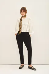 Pantalón babucha color mostaza, con elástico en la cintura y cordón ajustable con terminaciones metálicas. Tiene bolsillos diagonales en el frente y falsos bolsillos ojal en la espalda.