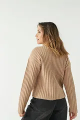 Sweater color beige de tejido de punto acanalado, con escote en V y corte ligeramente holgado.