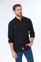 Camisa de lino color beige, de manga larga, con cuello clásico y bolsillo en el pecho.