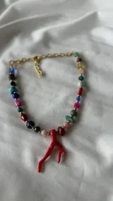 Collar corto de cuentas de colores con dije de coral rojo.