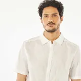 Camisa blanca de manga corta con cuello clásico y estampado de hojas.