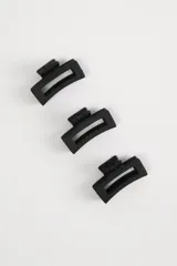 Pack de tres pinzas para el pelo color negro, de plástico rígido con diseño geométrico.